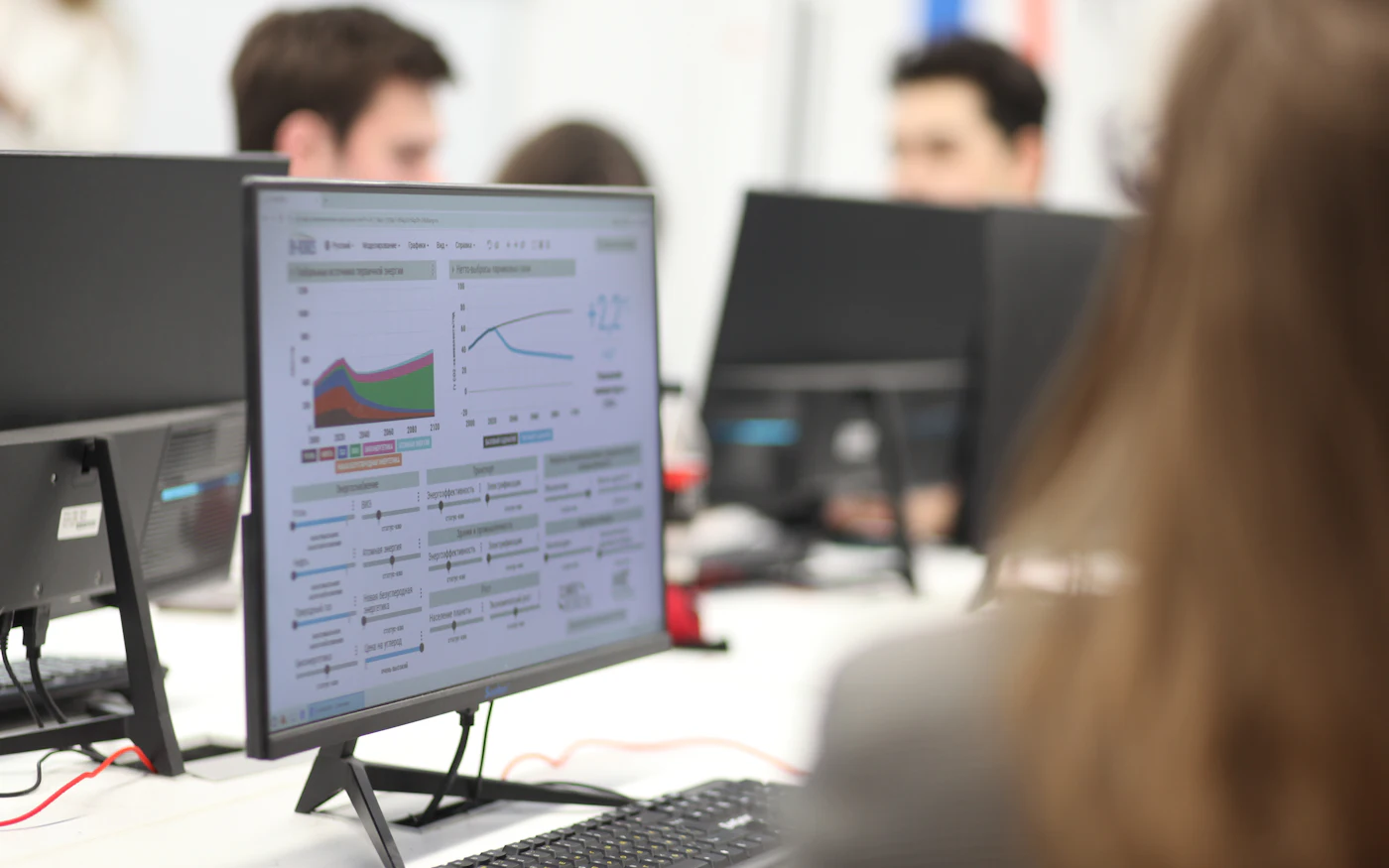 Analysts working at monitors showing charts