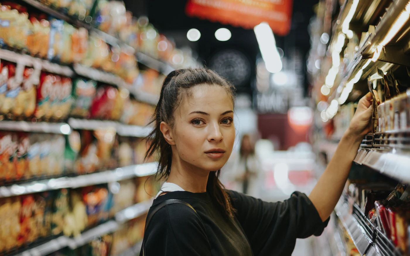 Shopper choosing products in a grocery aisle